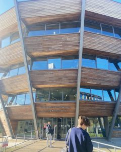 A large modern wooden structure with large modern windows on a lake.