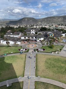 View of the city, the streets and a grassy area from top of Mitad del Mundo museum