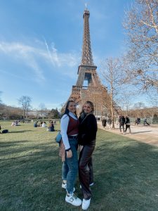 Alex Burkeen and I standing on a grass field in front of the Eiffel Tower, clear blue skies.
