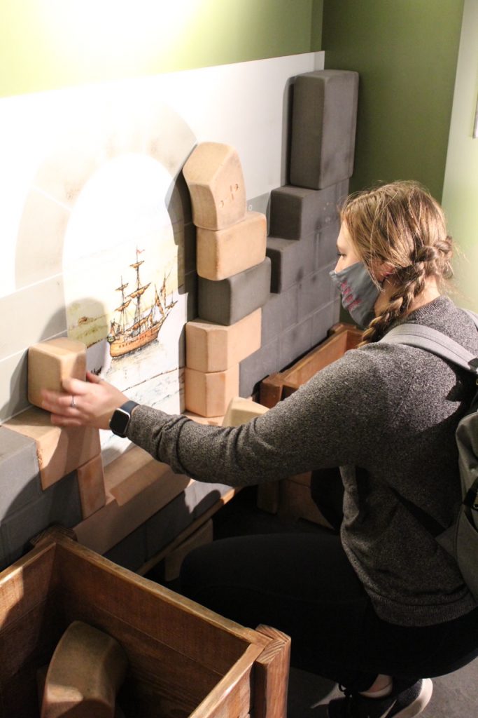 girl using blocks to build the archway of a castle