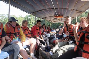 Pictured is a group of students in a boat wearing life jackets.