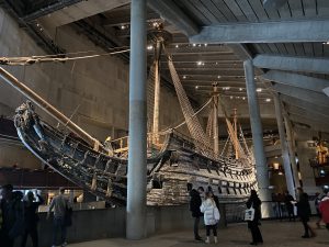 Inside a dark museum with a giant wooden 17th century warship in the middle of the building.