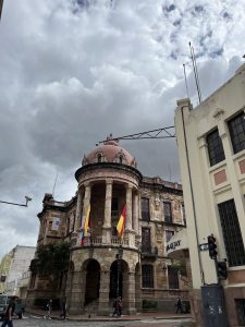 a Building that appears European in architecture, with Ecuadorian flags on it