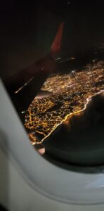 View from the plane window overlooking Marseille at night. Each building looks like a little speck of light in a sea of black