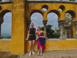 Megan (right) and Sofia (left) near the yellow walls of Pena Palace, laughing 