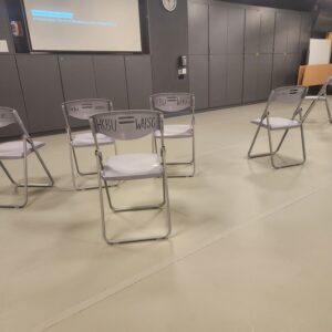 A picture of my mindfulness class, which is an open room, with a projecter screen at the front and a few foldable chairs arranged around the room. 