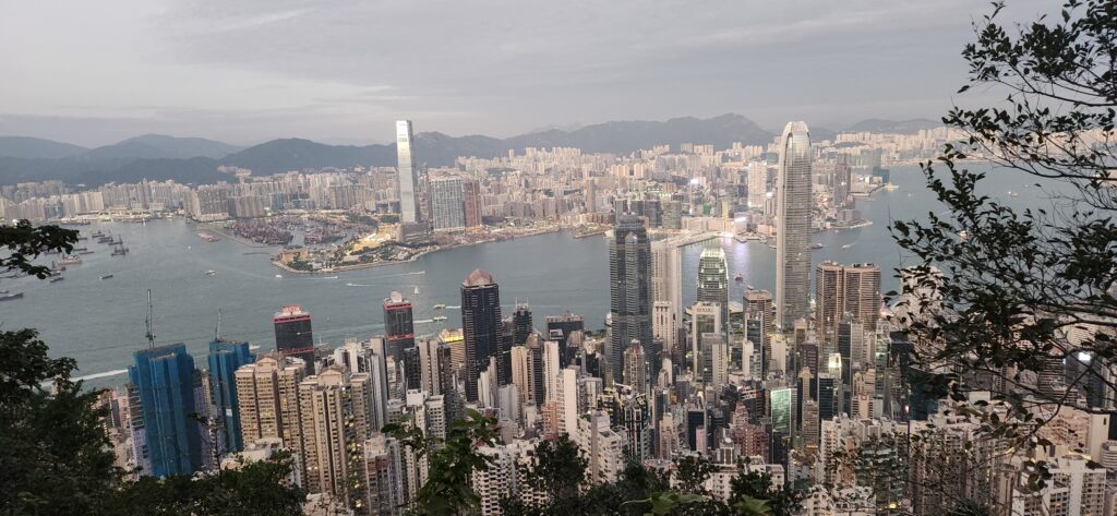 View over Hong Kong from Victoria's Peak, over the water and the buildings reaching up to the sky. 