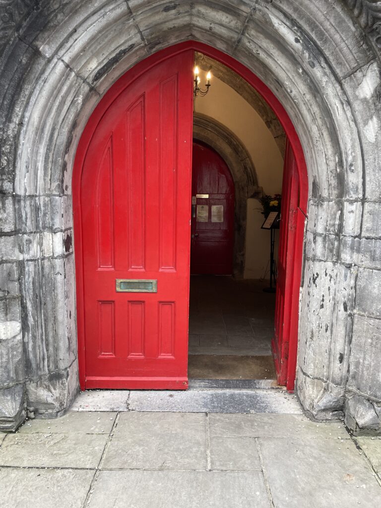 an arched doorway with a red door