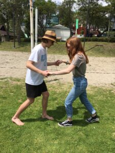 Pictured are two of my international friends, who are holding hands and rhythmically stepping, are trying to learn the steps to Salsa dancing.