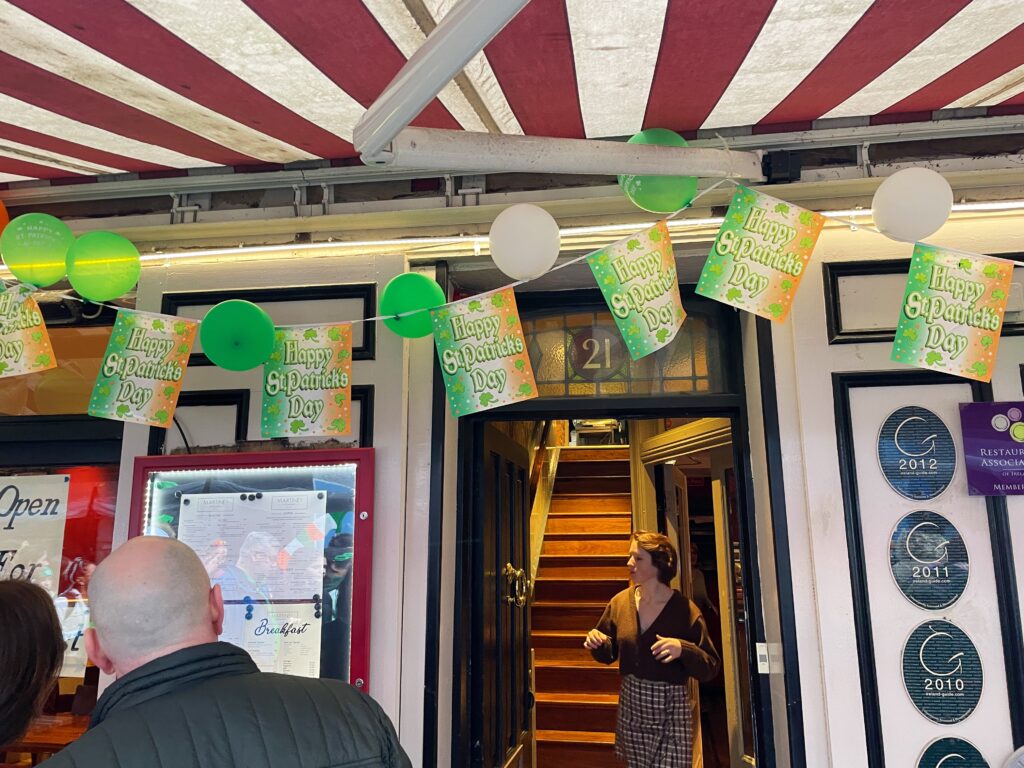 a restaurant with a happy st. patrick's day banner strung up outside it