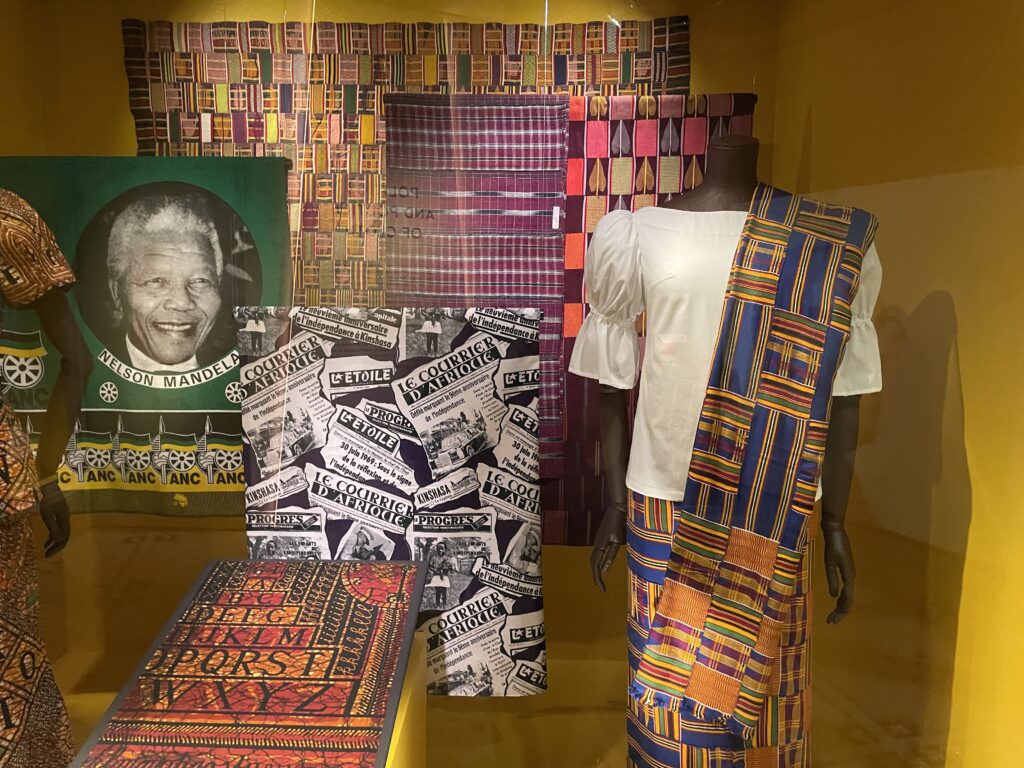 a museum display with different pieces of textile in African prints