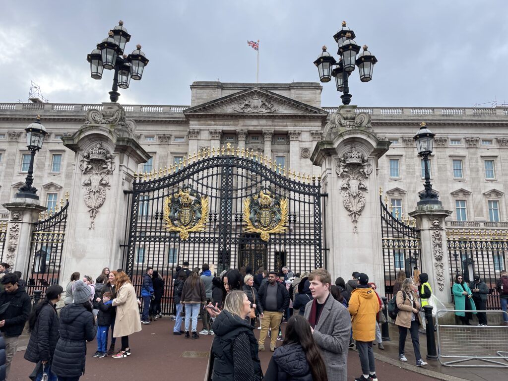 the gates to Buckingham Palace; black gates with gold accents and white stone pillars