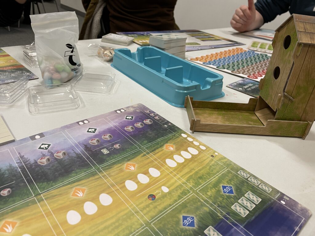 the board game wingspan. cardboard game pieces and a blue plastic tray