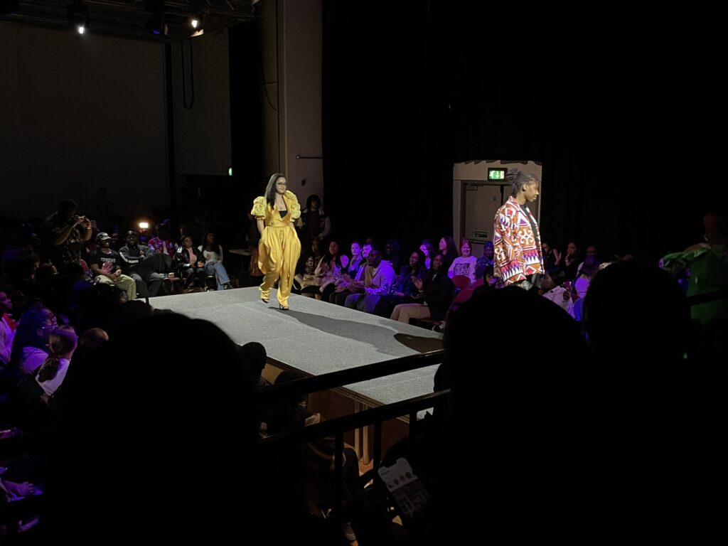 a woman wearing a yellow dress walking the runway