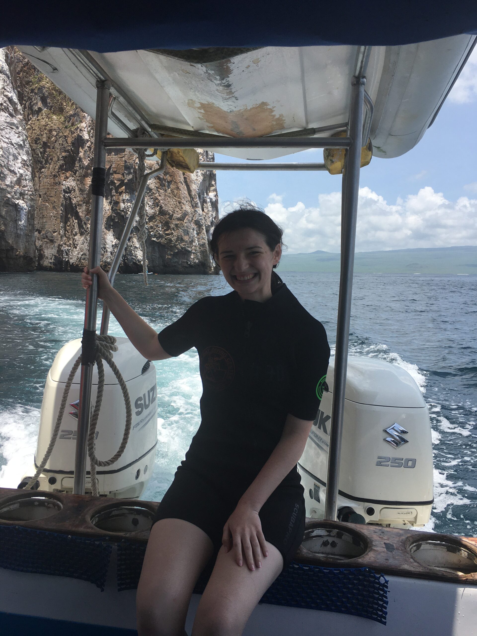 Pictured is me in a boat next to Kicker Rock. In the photo, I am wearing a wet suit, as I had just got snorkeling next to Kicker Rock. 
