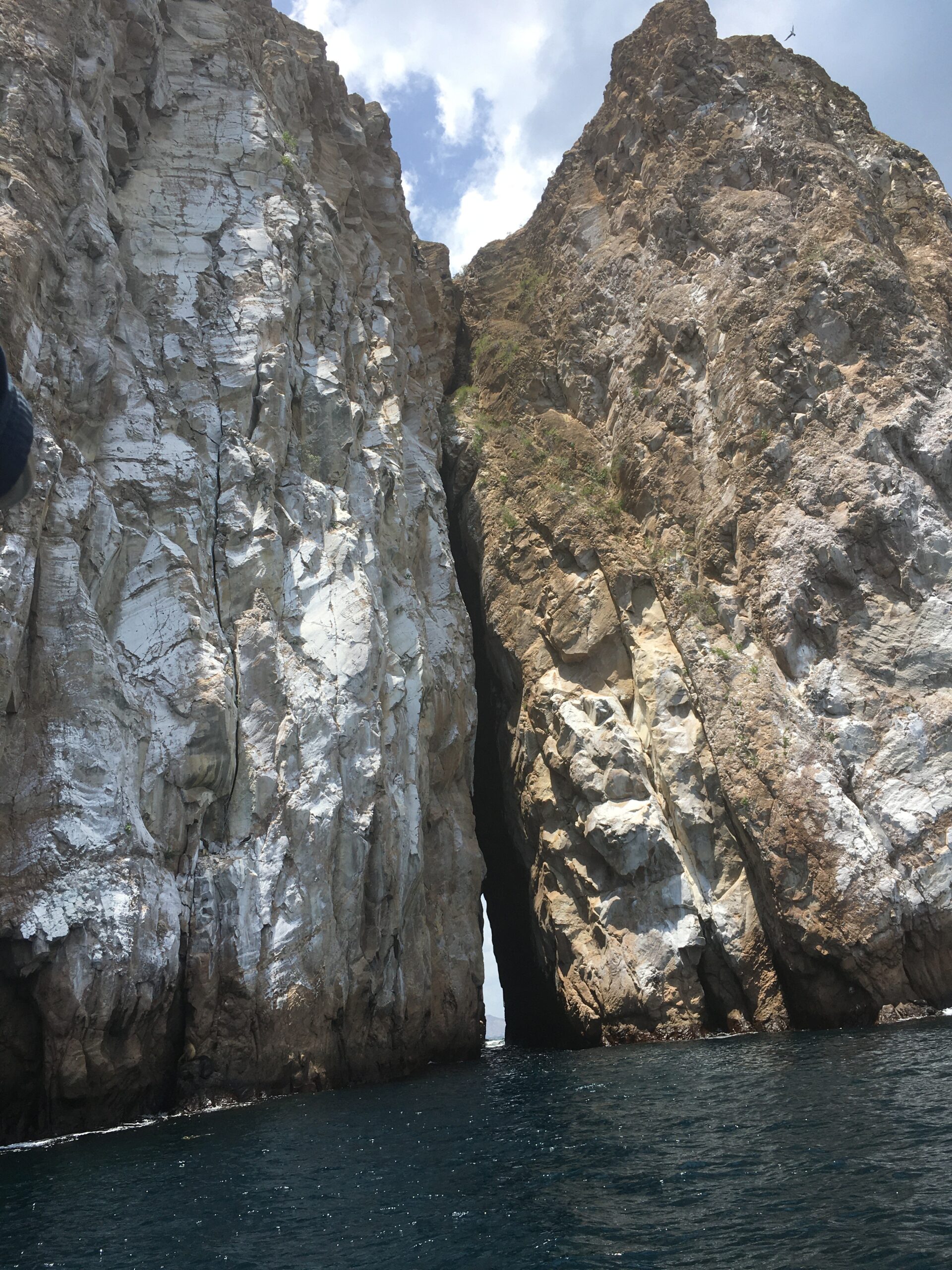 Pictured is part of Kicker Rock. From this viewpoint, it appears as two giant rocks in the pacific ocean. Both rocks are right next to each other with a small passageway in-between them. 