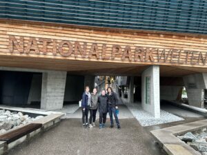 From left to right; Sage, Rachel, Lizzie, and Andrew smile for the camera in front of a museum/exhibition dedicated to learning more about the environment and Austria's national parks.