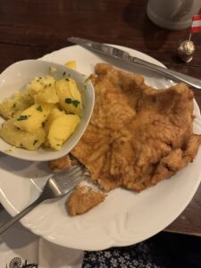A picture of Wiener Schnitzel with parsley potatoes on the side. 