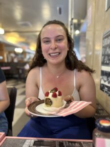 Lizzie smiling before diving into a vanilla and raspberry cake at the famous Viennese cafe, Aida.