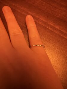 Close up of Clara’s right hand with a silver braided ring on her pinky finger 