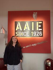 A picture of Lizzie standing in front of the big sign welcoming people into the Institute.