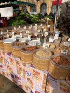 Market stand with basket upon basket of different types of nuts from which people can scoop out what they want.