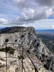 View from the peak of Sainte Victoire, with a railing and a bluff overlooking the valley