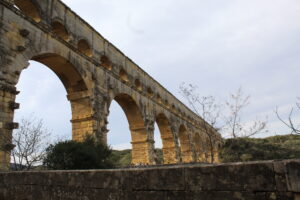 Image of the Pont du Gard from below, with the aqueduct stretching across the image
