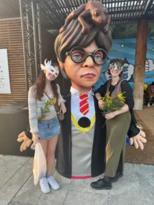 My friend and I wearing our carnival masks standing next to a Harry Potter trash can.
