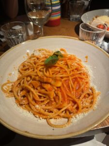 Image of a plate of pasta with a sprig of basil on top