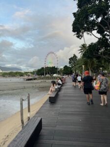 Beach boardwalk with people and ferris wheel
