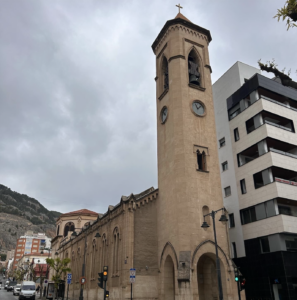 a sand colored church with a very tall clocktower