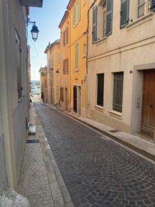 View down a small street with apartments lining eater side down to the waterfront.