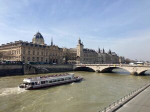 Image of the Sein in Paris, with a river boat about to pass under one of the bridges between île de la Cité
