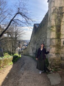 Me standing next to a stone wall leading down into the town of Blois