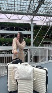 Student waiting for flight to Ireland with her luggage.