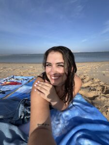 A girl smiling with the ocean in the background