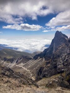 A view of the mountains west of Rucu Pichincha from the summit. Sharp dramatic mountains rise up out of the valleys covered in clouds below.
