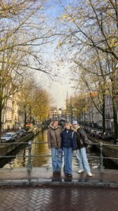 Three girls posing in front of a canal in Amsterdam.