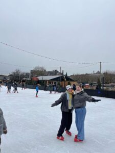 Two girls posing for a photo on an ice rink