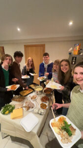 Group of people gathered around a table with food.