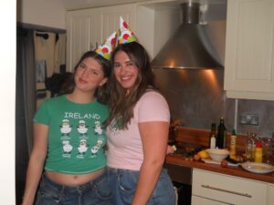 Two girls wearing party hats smiling