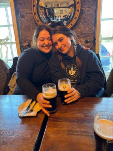 Two girls smile holding drinks