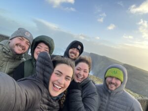 6 people stand in the wind smiling
