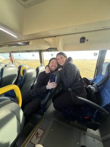 Two people smiling and hugging on a bus