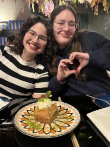 2 girls celebrating a birthdy with cake.