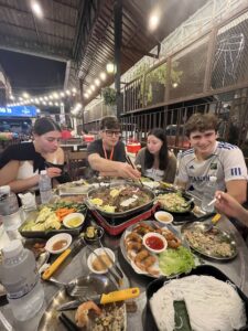 Four people eating a family style dinner in Phnom Penh, Cambodia