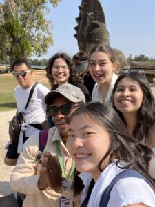 Four young women taking a photo with tour guide at Angkor Wat in Siem Reap, Cambodia
