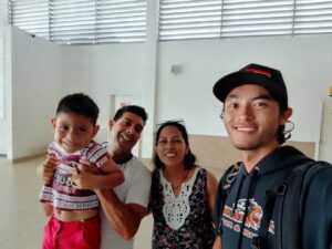 People standing for a photo at the airport saying goodbye.