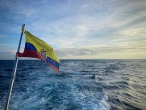 An Ecuadorian flag flying off the stern of a boat.